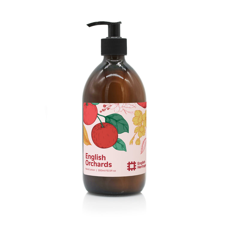An English Heritage English Orchards apple scented moisturising hand and body lotion in amber glass bottle with black lotion pump and apple illustrated label