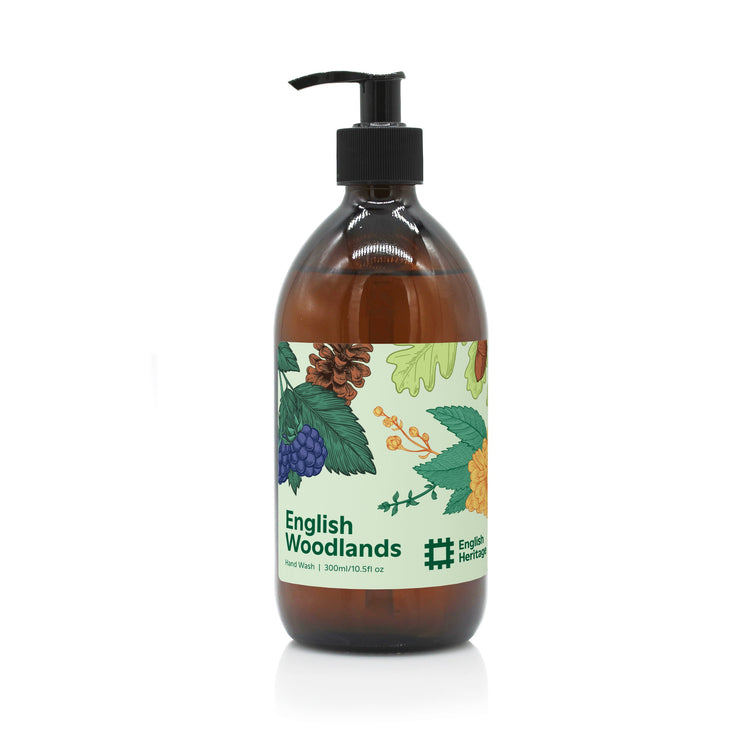 An English Heritage English Woodlands scented hand wash in amber glass bottle with black lotion pump and woodland illustrated label