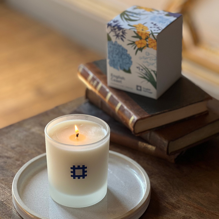 The English Heritage coast candle is shown lit alongside its box