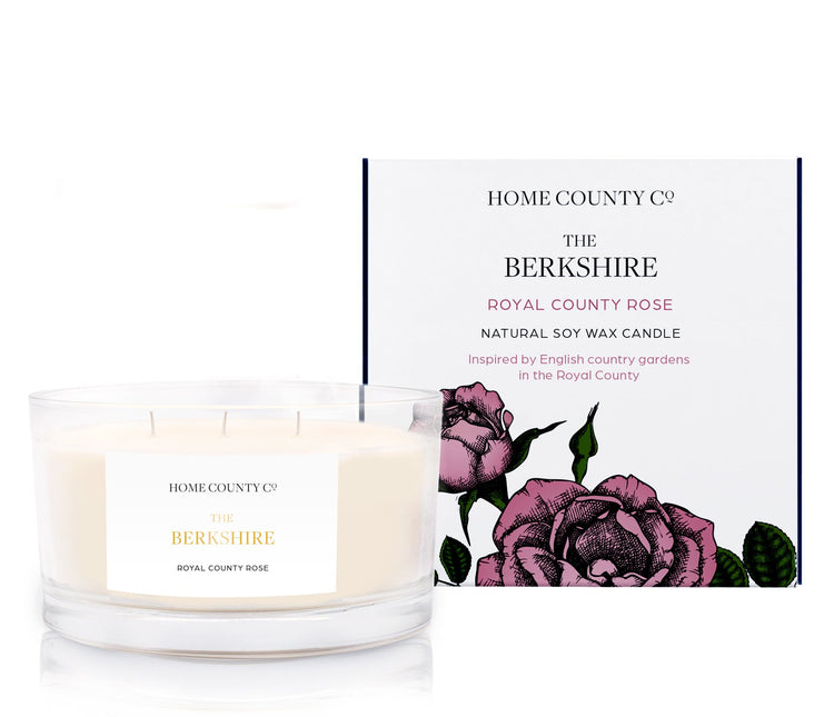 A royal county rose scented 3 wick candle from the Home County Co. is shown next to its eco-friendly candle packaging box.