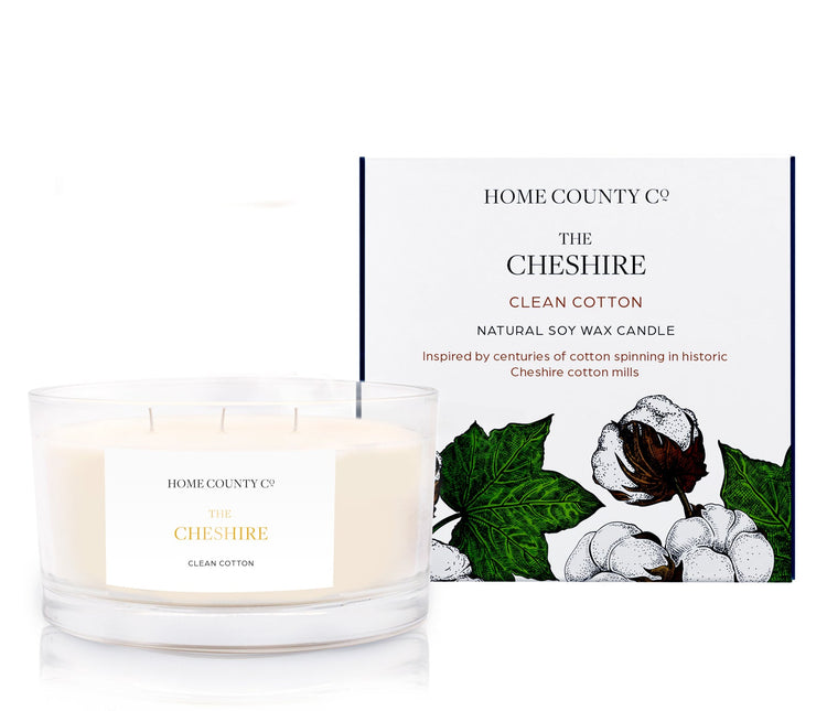 A clean cotton scented 3 wick candle from the Home County Co. is shown next to its eco-friendly candle packaging box.
