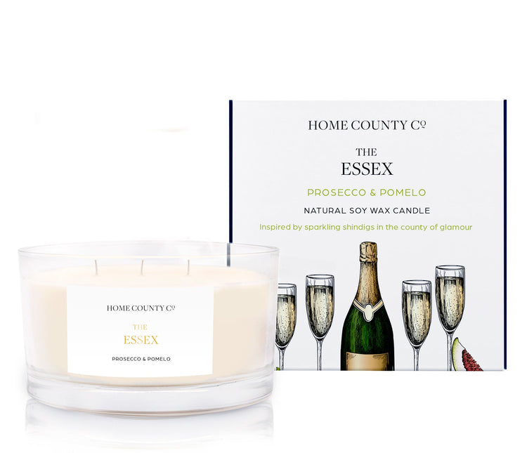 A Prosecco and pomelo scented 3 wick candle from the Home County Co. is shown next to its eco-friendly candle packaging box.
