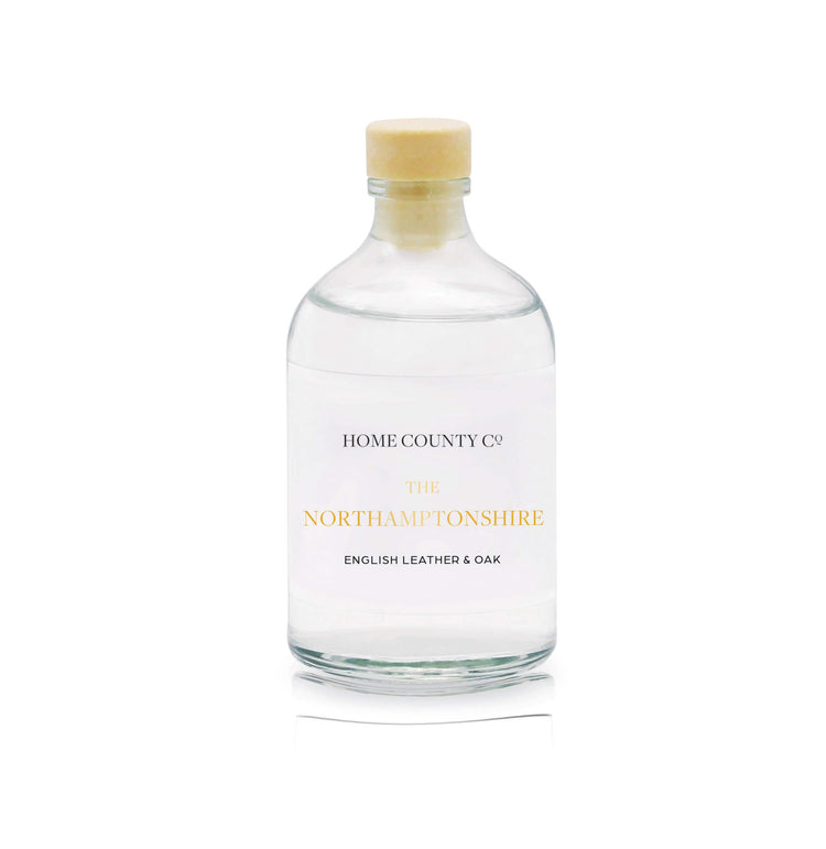 A English leather and oak reed diffuser refill is shown in a recyclable glass bottle