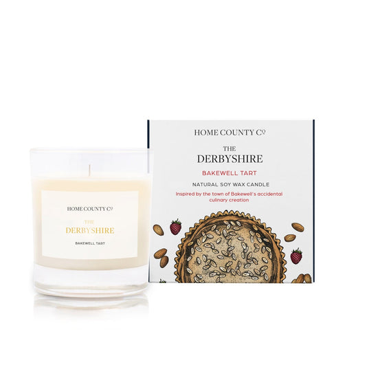 A Derbyshire Bakewell Tart scented candle is shown next to its eco-friendly illustrated candle boc