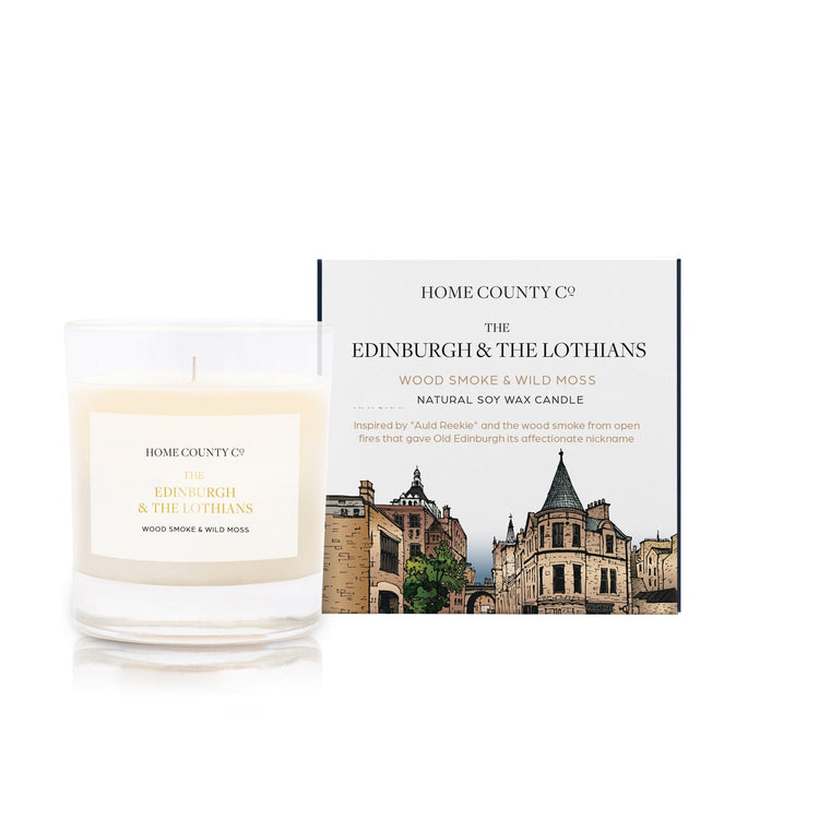 A wood smoke and wild moss scented candle from Home County Co. The cotton wick soy candle is shown next to the eco friendly candle box packaging which displays an illustration of Edinburgh&