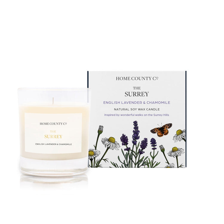An English lavender and chamomile scented candle from Home County Co. The cotton wick soy candle is shown next to the eco friendly candle box packaging.