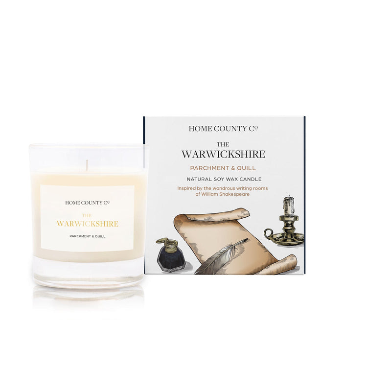 A parchment and quill scented candle from Home County Co. The cotton wick soy candle is shown next to the eco friendly box packaging.