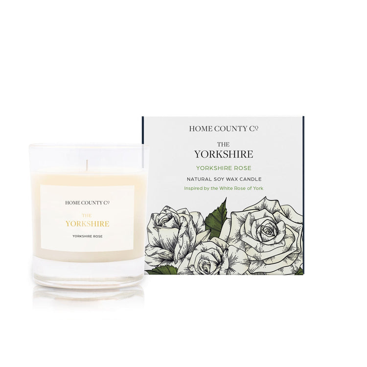 A Yorkshire rose scented candle from Home County Co. The cotton wick soy candle is shown next to the eco friendly candle box packaging.