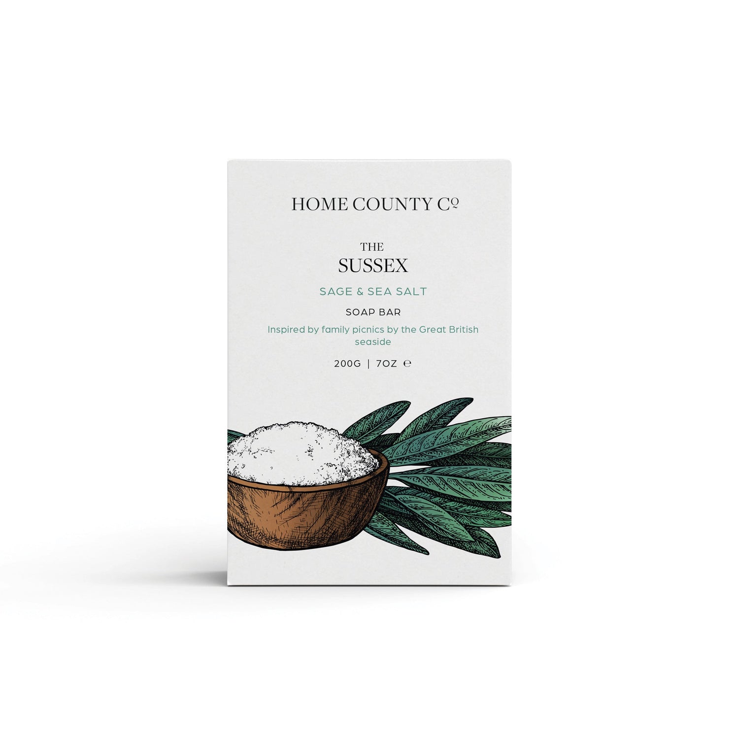 A sage and sea salt scented natural soap bar from the Home County Co. is shown in its sea salt illustrated recyclable soap bar wrap