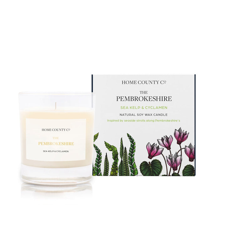 A sea kelp and cyclamen scented candle from Home County Co. The cotton wick soy candle is shown next to the eco friendly box packaging.